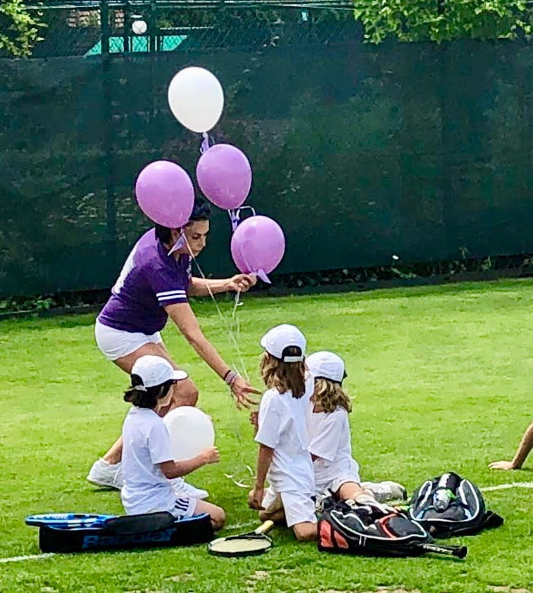 Lavender balloons with kids on the grass court