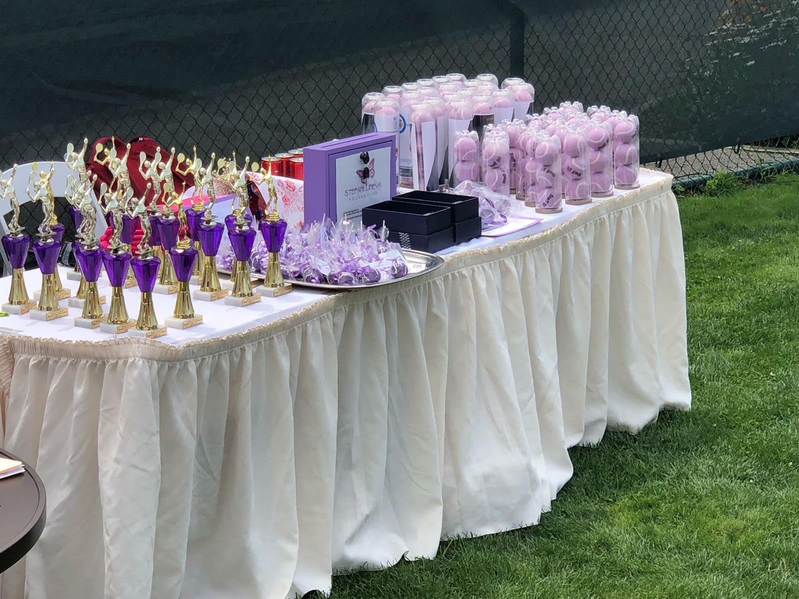 Awards table with purple trophies and pink tennis balls
